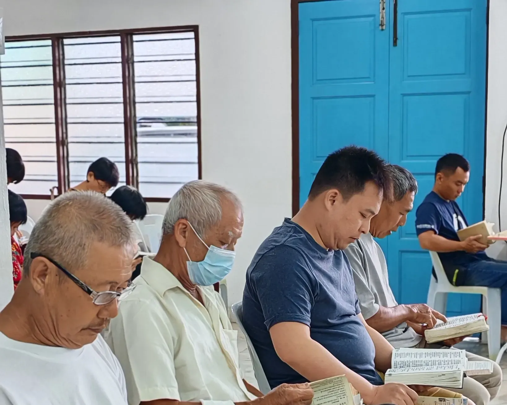 信徒喺教會禮堂一齊讀聖經