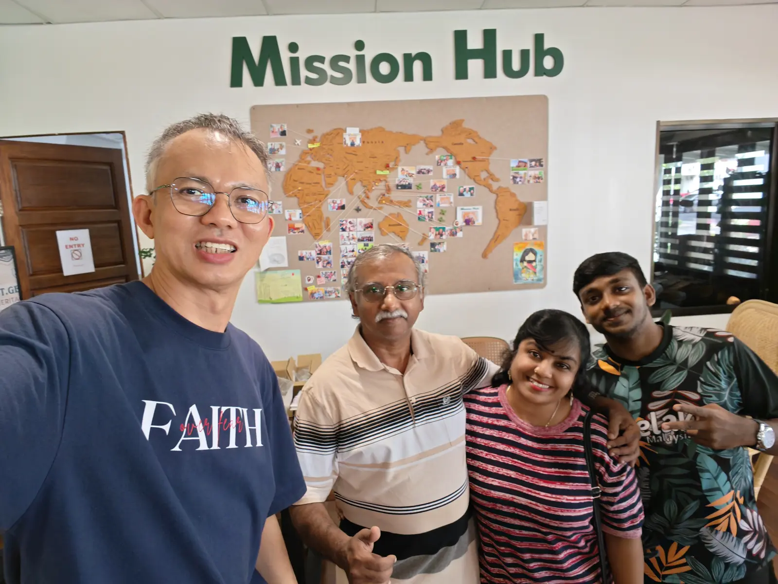 Pastor Jony with visitors in front of the world map at the Mission Hub