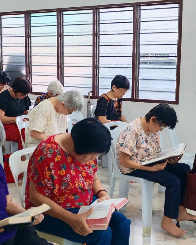 Women reading the Bible together in a church hall