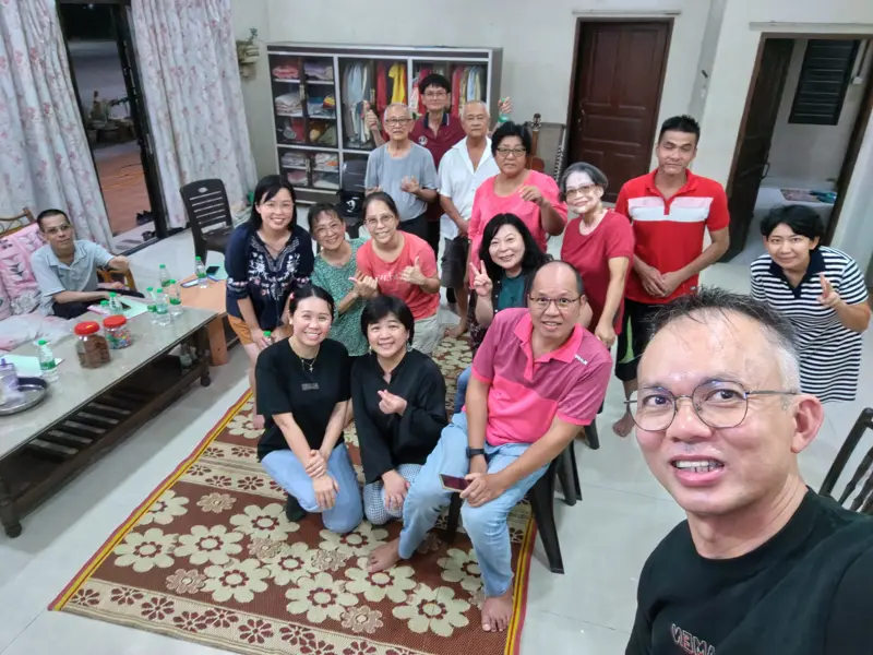 A smiling home fellowship gathered in a living room