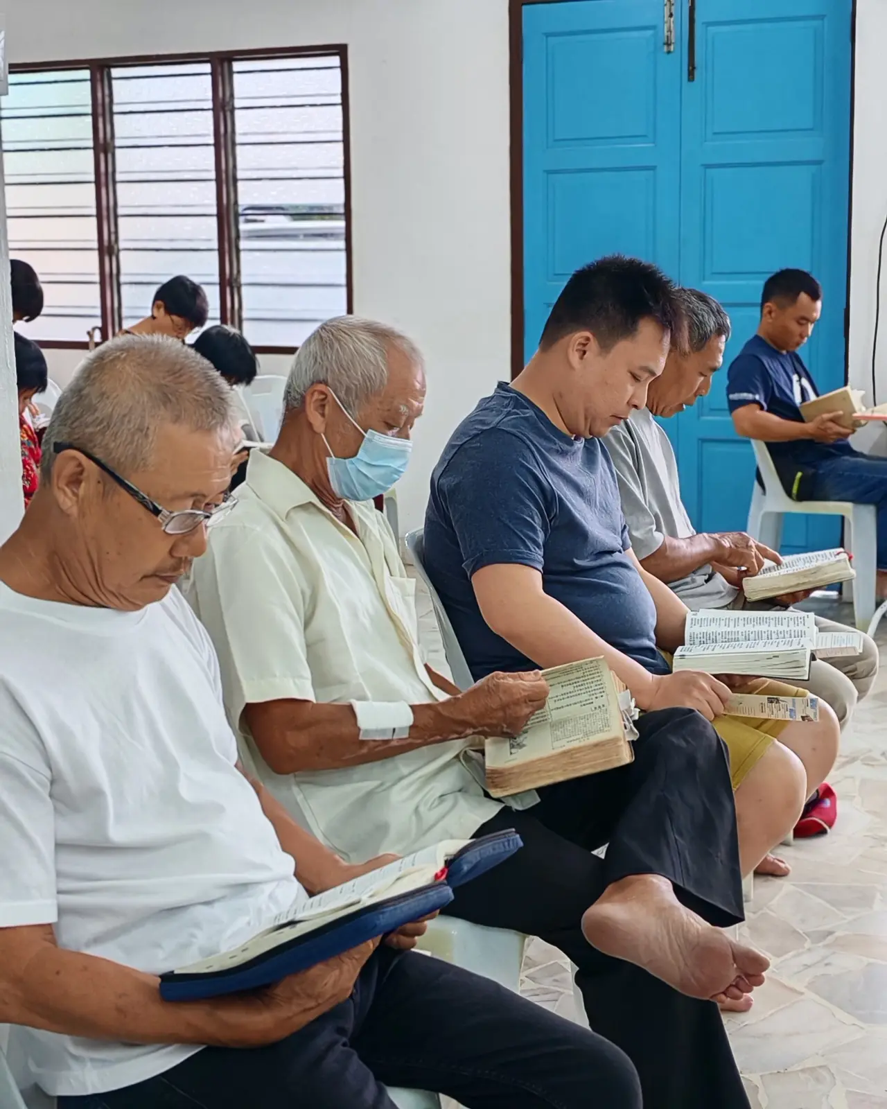 Men reading their Bibles together in a bright church hall