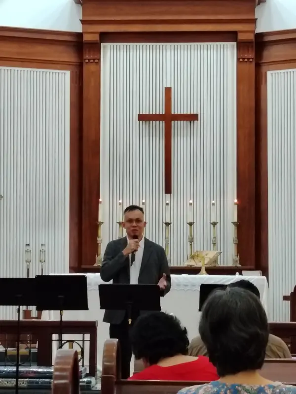 Pastor Jony preaching in a church sanctuary