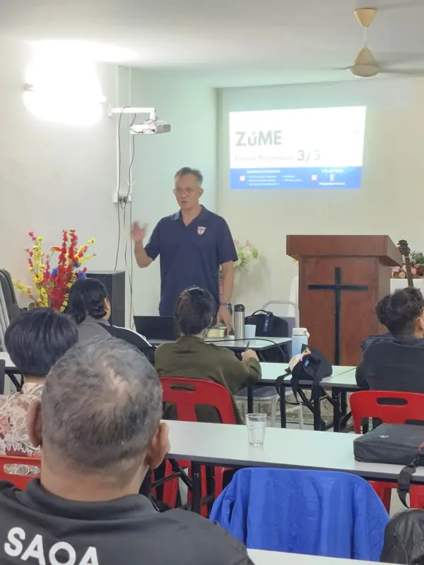 Pastor Jony teaching a Zúme session beside a cross
